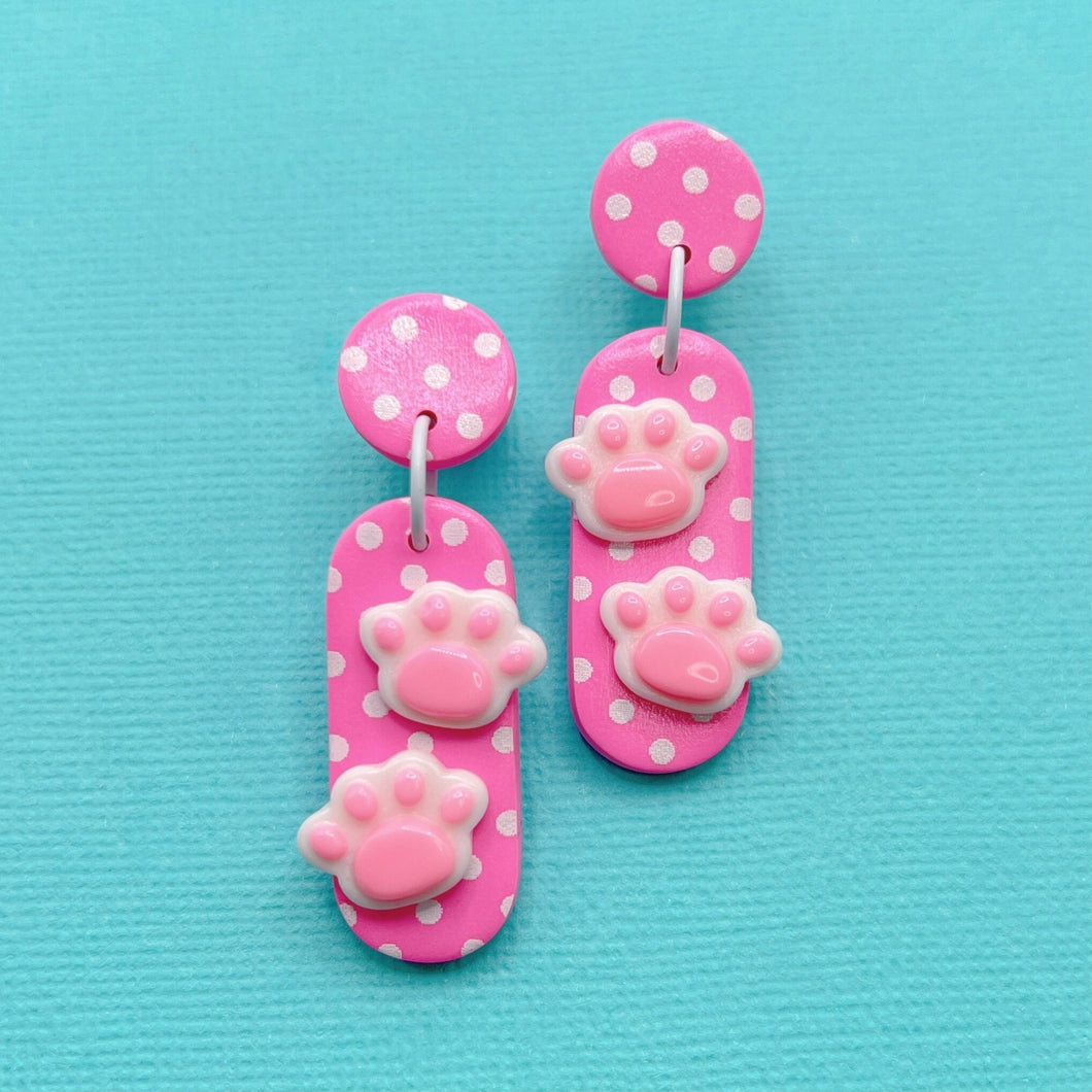 Bright pink polka dot oval polymer clay stud earrings with paw charms